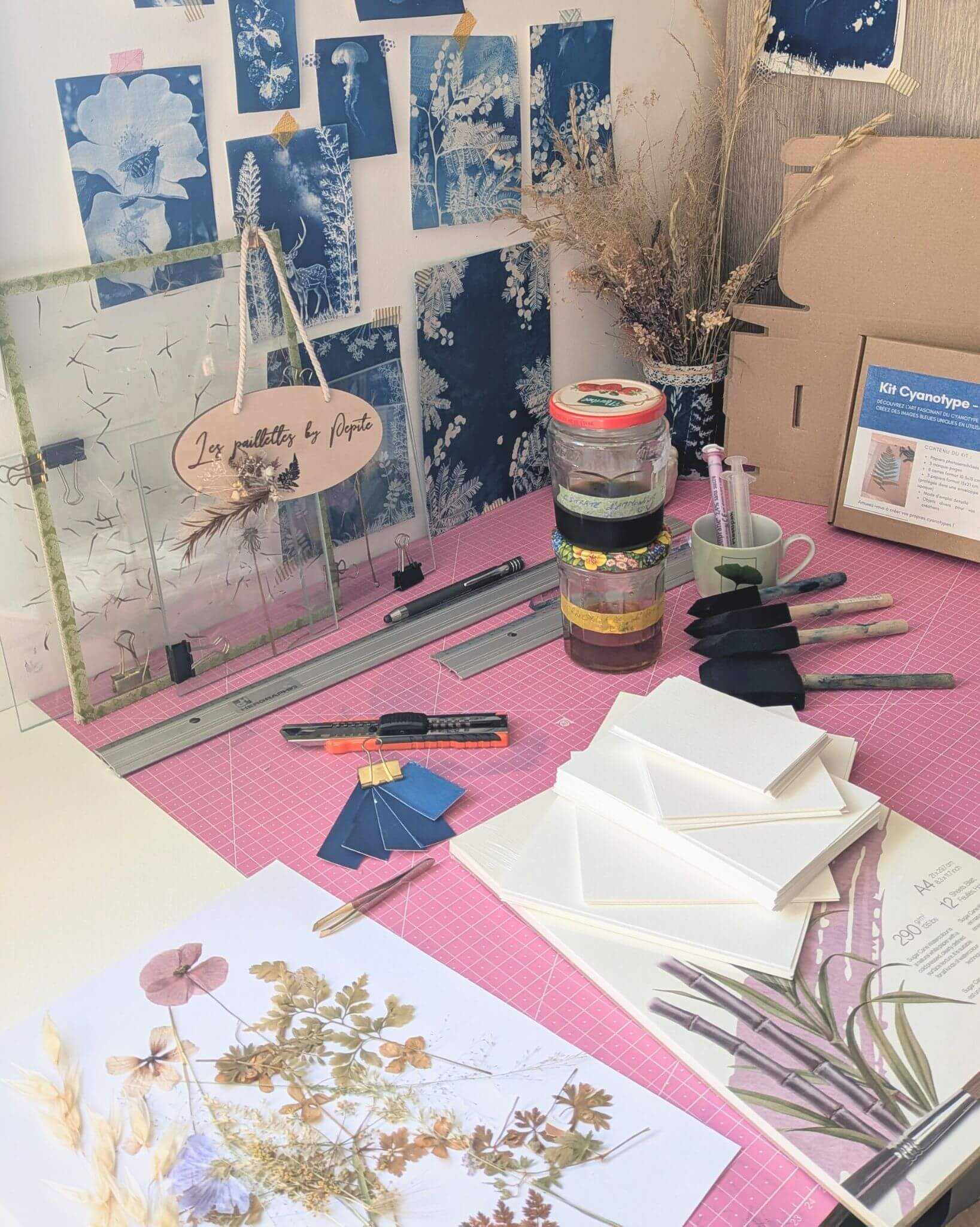 Matériel artisanal pinceaux papiers cyanotype plantes table de travail